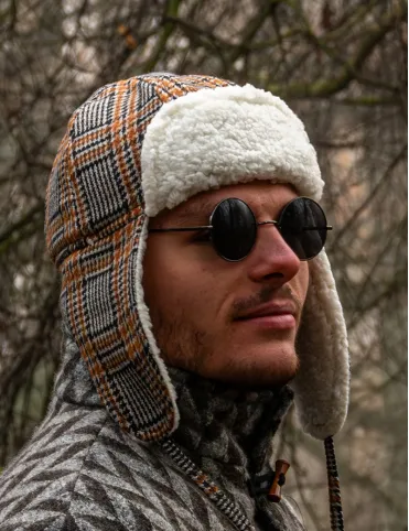 Warm woolen aviation-style earflap hat made of red tartan fabric