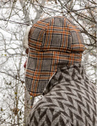 Warm woolen aviation-style earflap hat made of red tartan fabric