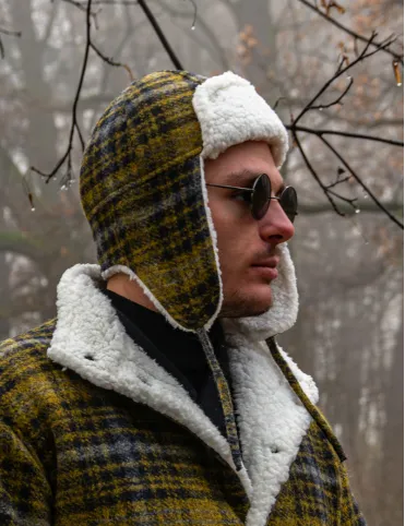 Warm woolen hat with earflaps in aviation style made of Tartan fabric.