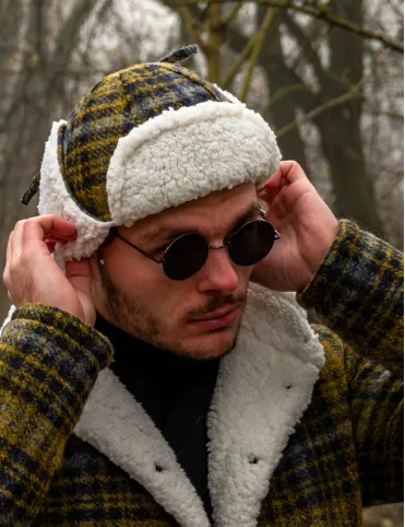 Warm woolen hat with earflaps in aviation style made of Tartan fabric.